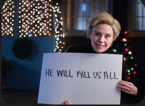 A still image of actress Kate McKinnon holding a sign that reads, “He will kill us all.”  It is from a famous Saturday Night Live episode in 2016, in which Kate’s character is dressed as a Christmas caroler on the doorstep of a house she knows to be the residence of an Electoral College voter.  One at a time, Kate’s character reveals a series of large white cards that contains a narrative pleading not to certify the election for Trump because he poses an existential threat to humanity.