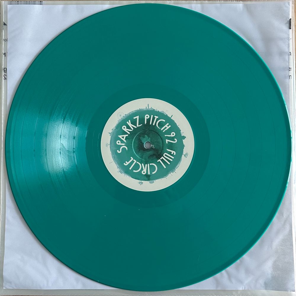A photo of the sea green vinyl variant of the ‘Full Circle’ album by Sparkz & Pitch 92 from 2024. 