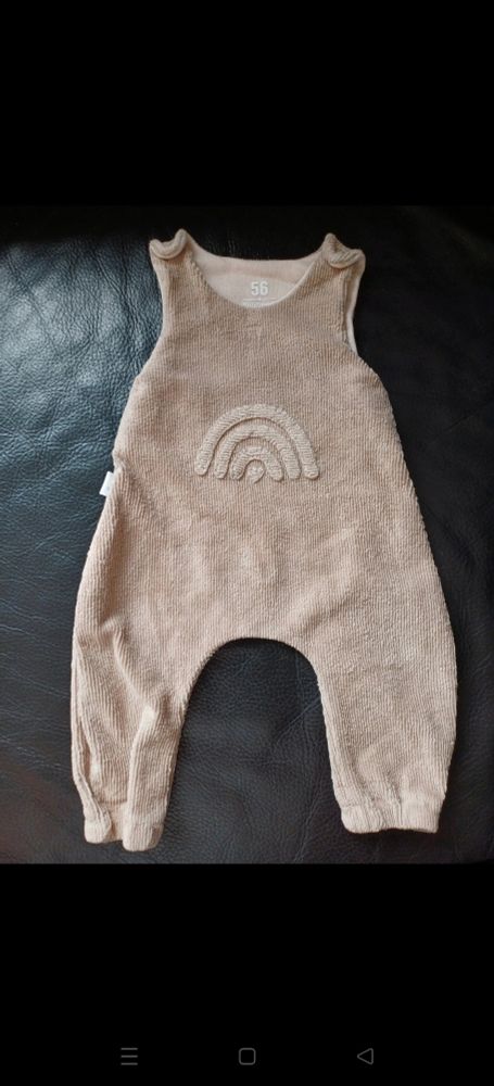 Baby Strampler in beige mit einer weißen Regenbogen Stickerei