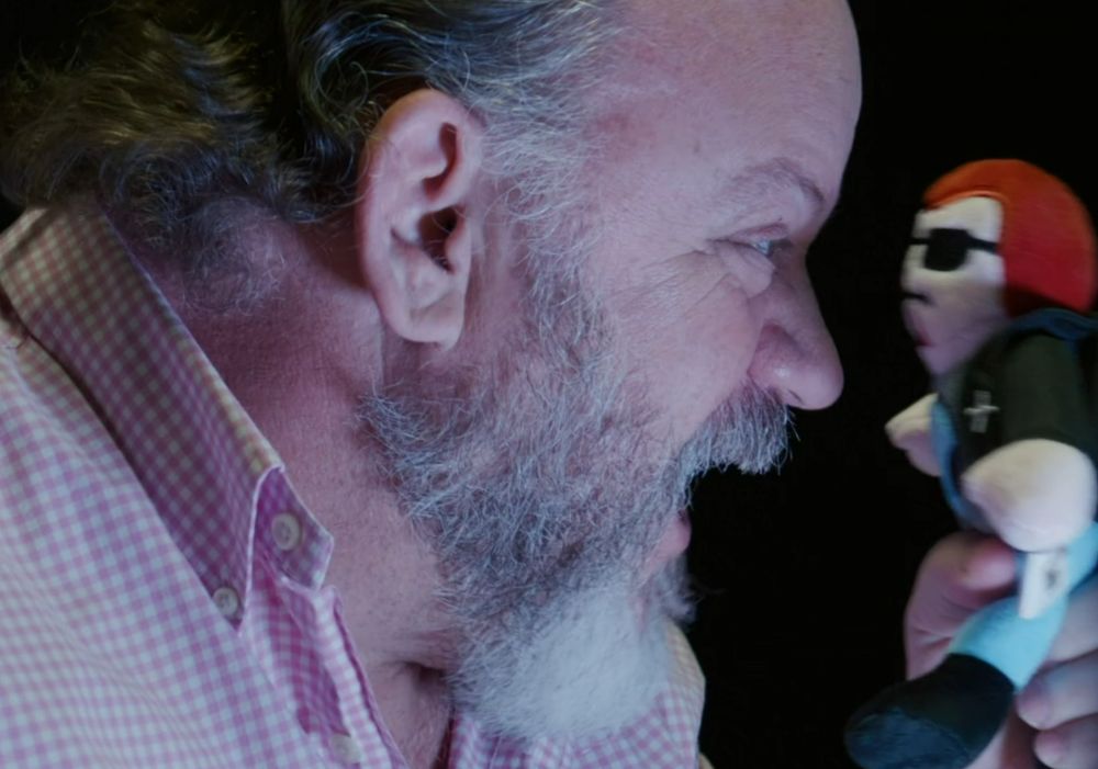 man screams at lil Postal Dude plush held 1 inch from his face