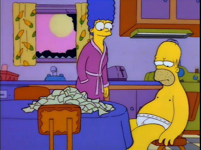 A scene from The Simpsons shows Marge and Homer Simpson in their kitchen during sunrise or sunset, with a pink and yellow sky visible through the window. Marge is standing and wearing a purple bathrobe, looking concerned. Homer sits slouched at the table wearing only white underwear, looking defeated. In front of him is a large pile of plastic cheese wrappers stacked on the table. The mood is tense and somber despite the bright cartoon colors.