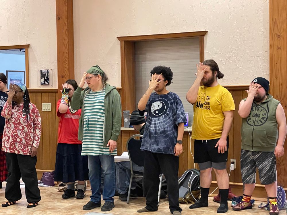 Actors cover their faces with their right hands in rehearsal for Jesus Christ Superstar.