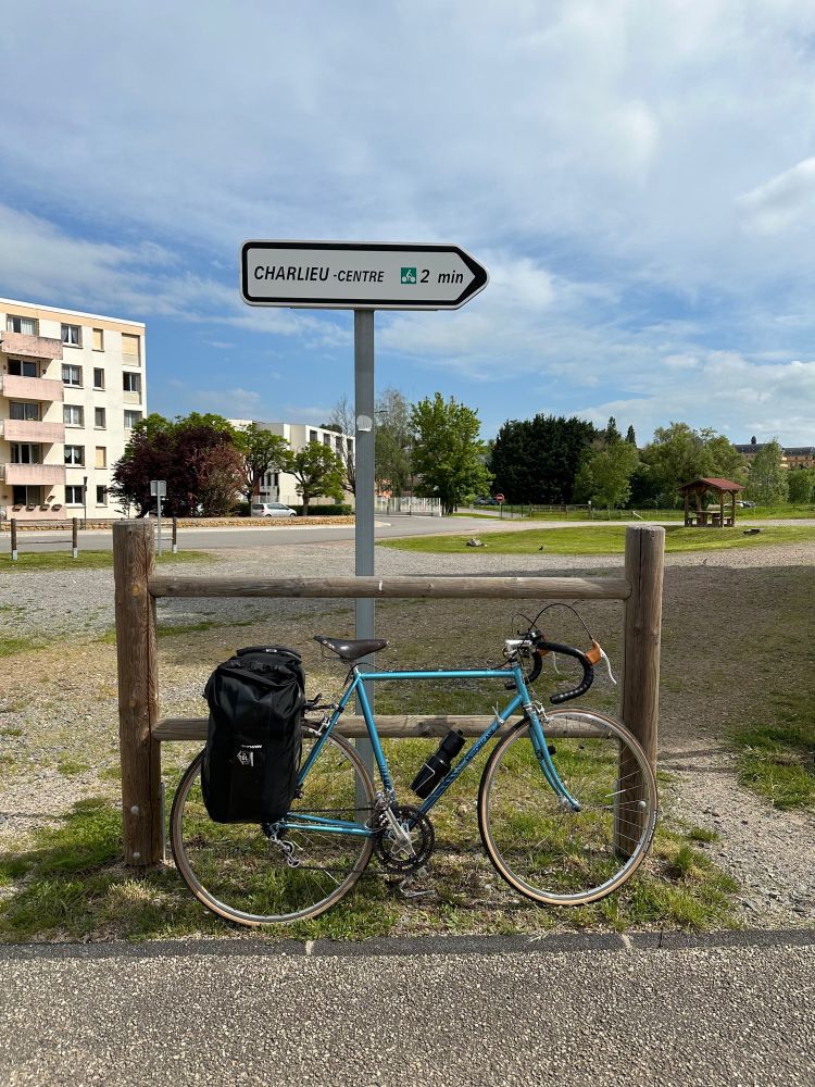 Un vélo motobecane devant le panneau de la ville de Charlieu