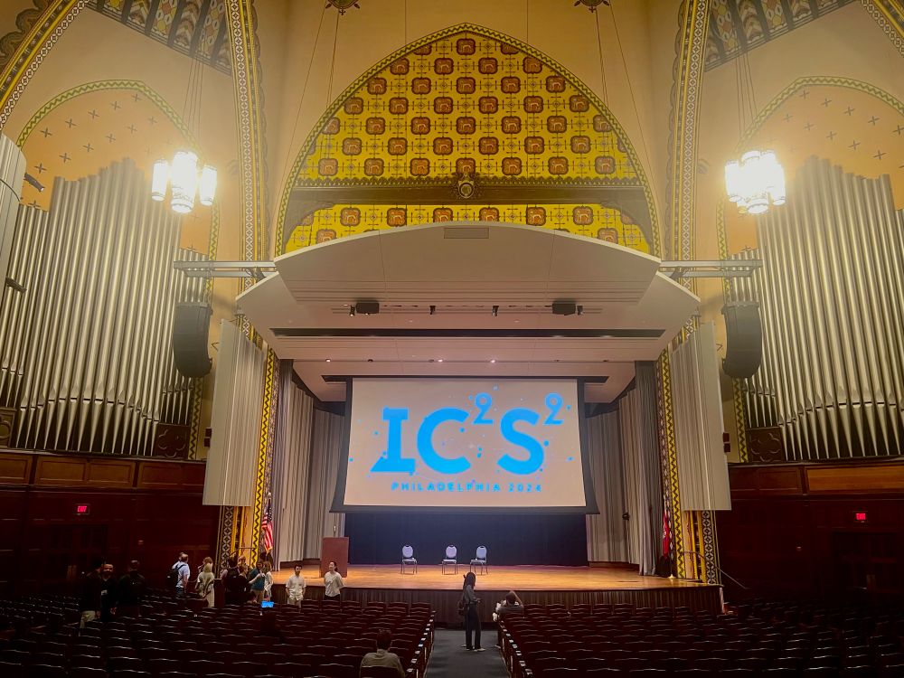 Interior of the (empty) Irvine auditorium at UPenn. “IC2S2” is displayed on a large projector screen