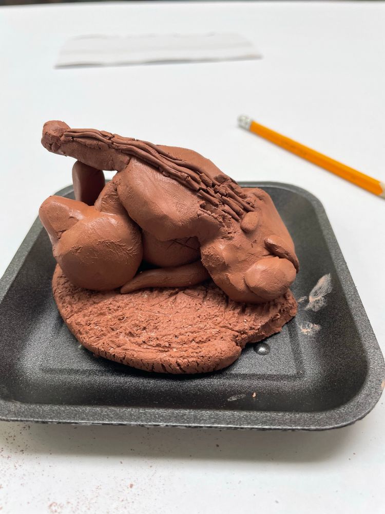 Clay creation of a violin on a cat 