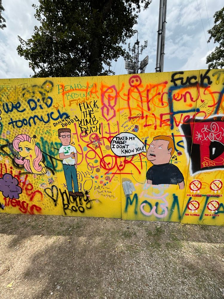 A picture of a spray painted wall featuring Bobby and Hank Hill characters 