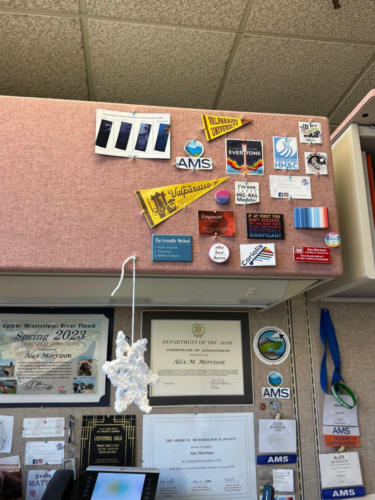 A collage of stickers and magnets including a mini Valparaiso University Flag, a magnet that says “If at first you don’t succeed, try two more times so your failure is statistically significant”, a magnet that says “The scientific method: 1. Fuck around 2. Find out 3. Write it down”, a bisexual flag pin, a sticker that says “I’m in my science era”, and several more science and engineering related stickers/magnets.