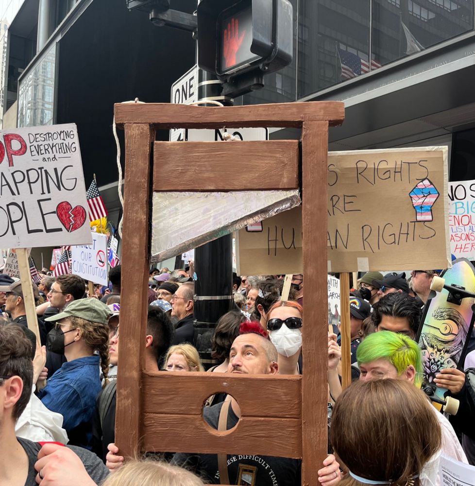 A protester holds a mock guillotine.