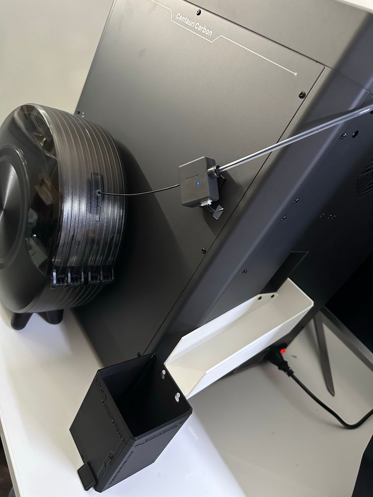 Printer poop slide with mini Centauri Carbon collection cup. Sunlu filament dryer used to feed filament to the printer 