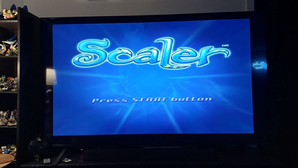 A TV screen with the title screen of the ps2 game "Scaler" on it. With "Press start button" bellow. 