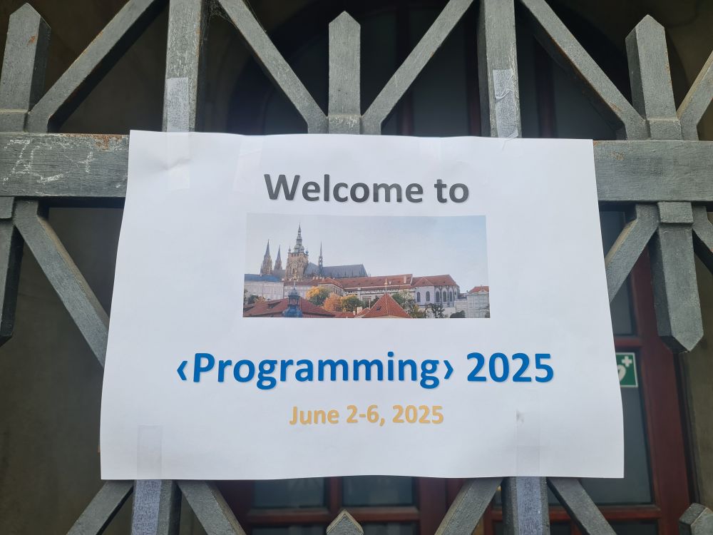 A photo of a Poster saying: Welcome to <Programming> 2025 June 2-6 2025.
There is a picture of Prague on the poster.