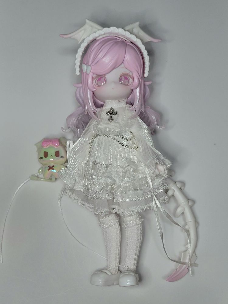 ルルリン物語、骸骨翼異色。白い蝙蝠羽付きヘッドドレス、黒同様にねりけし風のもので直接頭に装着。白いワンピース、胸元に十字の飾り。スカート部分に鎖飾りあり。白のパニエ。尻尾はフィギュア素体で白い骨っぽい形。お供はパールがかった白、頭にピンクのリボン付き。