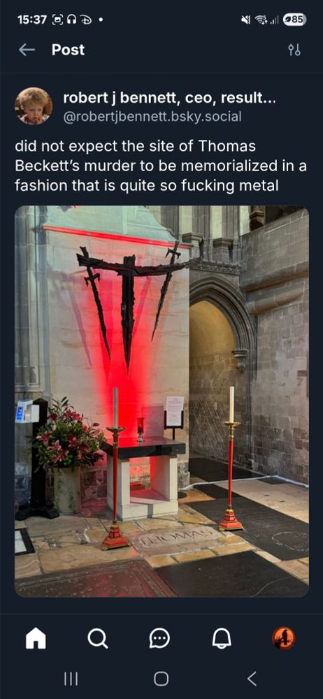 Thomas Beckets memorial 2 swords facing down on a cross with a curved cross beam lit from below by a red light