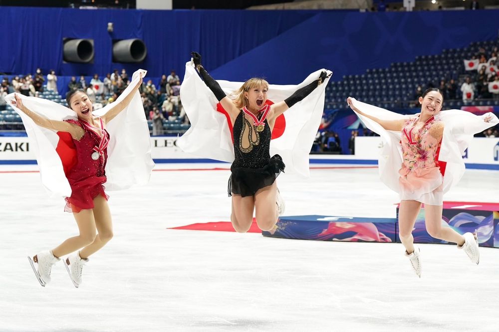 Mone Chiba, Kaori Sakamoto e Yuna Aoki pulando sincronizadas no gelo pós cerimônia de medalhas do NHK Trophy 2024
