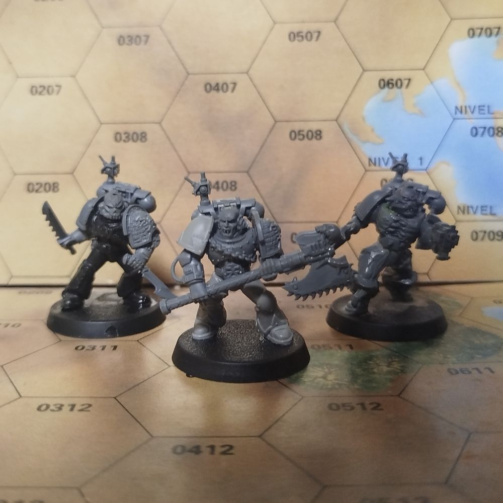 Tres marines del caos secuestrados por la Inquisidora Waller para servir en su Kill Team.

A la izquierda hay un marine armado con dos cuchillos y que porta un casco estilizado en forma de calavera.

En el centro hay un marine de los devoradores de mundos blandiendo una gran hacha sierra. Una cadena recorre la armadura de su pecho y un emblema de Khorne, dios de la Sangre y la Guerra, adorna su cinturón. No lleva casco por lo que se pueden apreciar los clavos del carnicero incrustados en su cráneo.

A la derecha hay un marine de los Portadores de la Palabra, con mutaciones por todo el cuerpo que se han extendido hasta la propia armadura que denotan su avanzado estado de posesión demoníaca. Dientes y cuernos brotan por todas partes de esta.

Todos los marines llevan hombreras de la Deathwatch con el símbolo de la inquisición y todas las mochilas llevan antenas con detonadores por si tratan de desertar.

