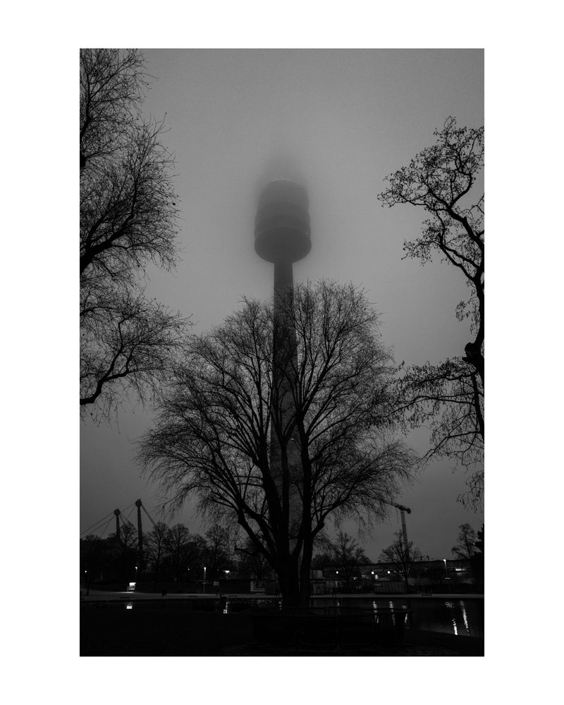 A monochrome photo of the MUnich TV tower in the misty evening.