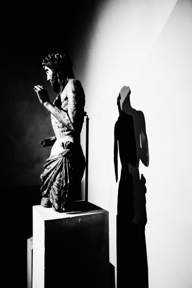 A statue of Jesus with a shadow behind it.