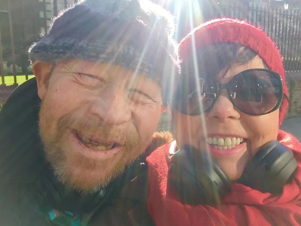 George and Audrey smile at a camera, the sunlight shining onto the lens