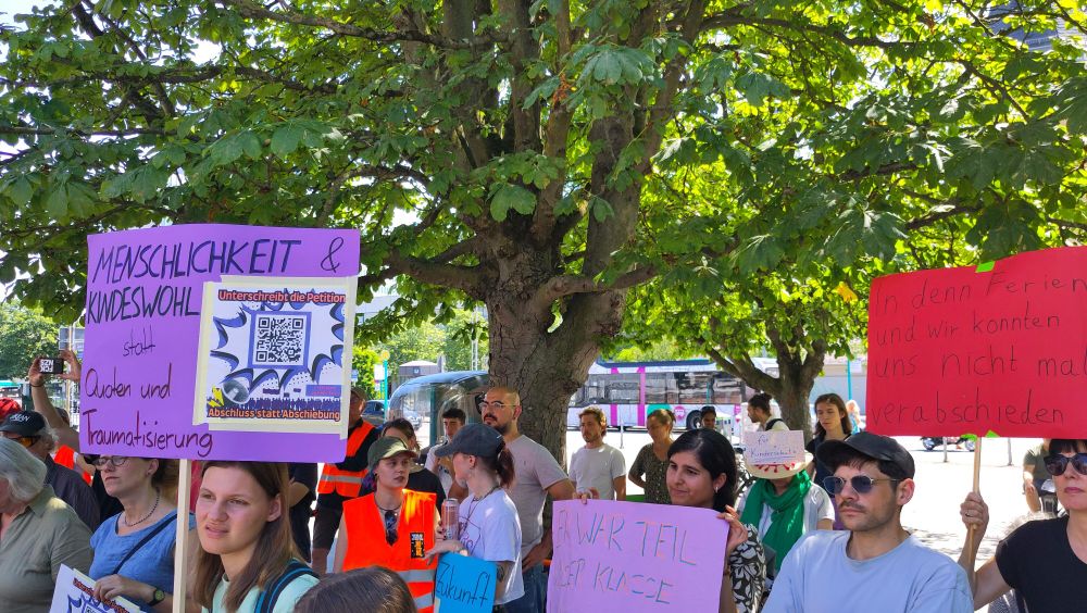 Teilnehmer:innen, Schild "Menschlichkeit und Kindeswohl".