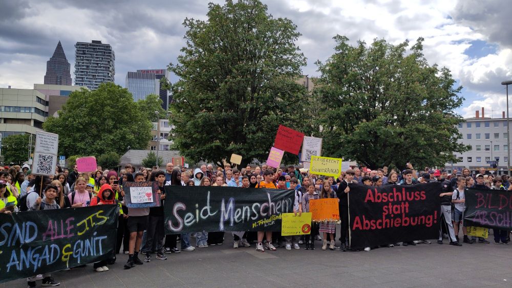 Bild der Auftaktkundgebung, Transparent "Abschluss statt Abschiebung"
