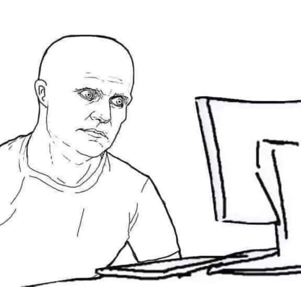 A man staring in horror at a computer monitor.