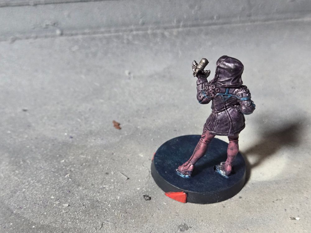 The back of the Fixer. Her hips are cocked to the right, and her right arm and hand rest there.