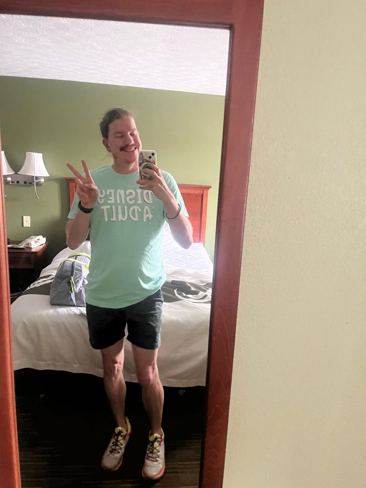 Me at hometown where I stay for a few nights at motel by home state,WV. Peace pose with held iPhone. Wore a chubbie camos and tshirt sea blue say “Disney Adult.” 