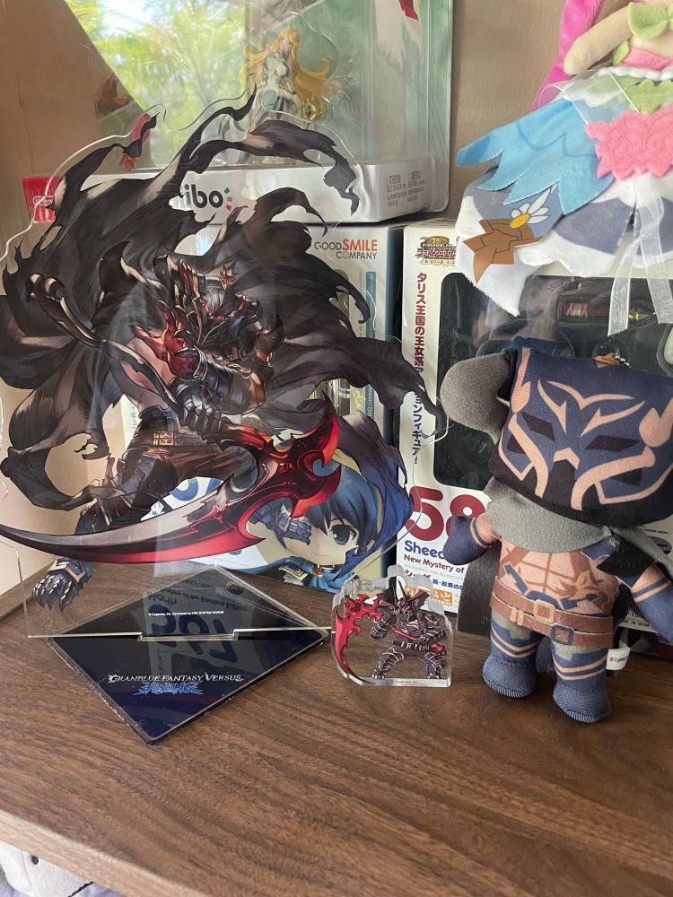 Vaseraga as a bit acrylic standee and a little one. As well as a plush on a shelf.