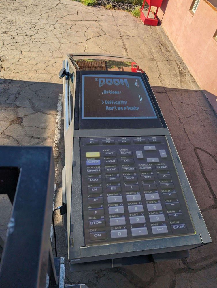 A Cybertruck, from above, but it's a TI-85 playing zdoom.