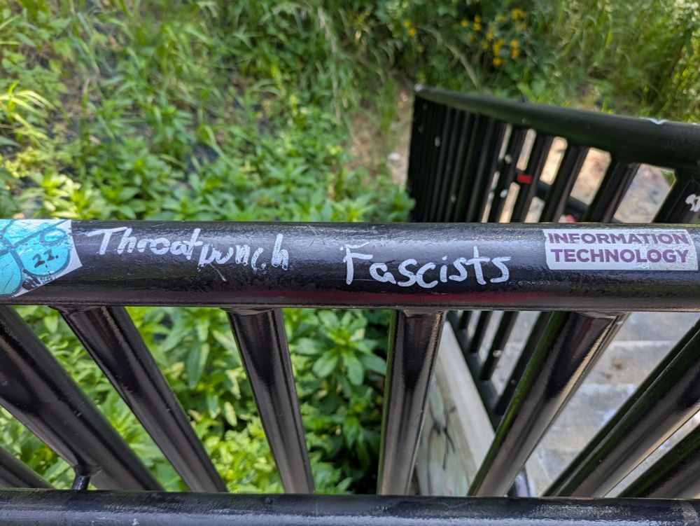 Graffiti on a railing that says 