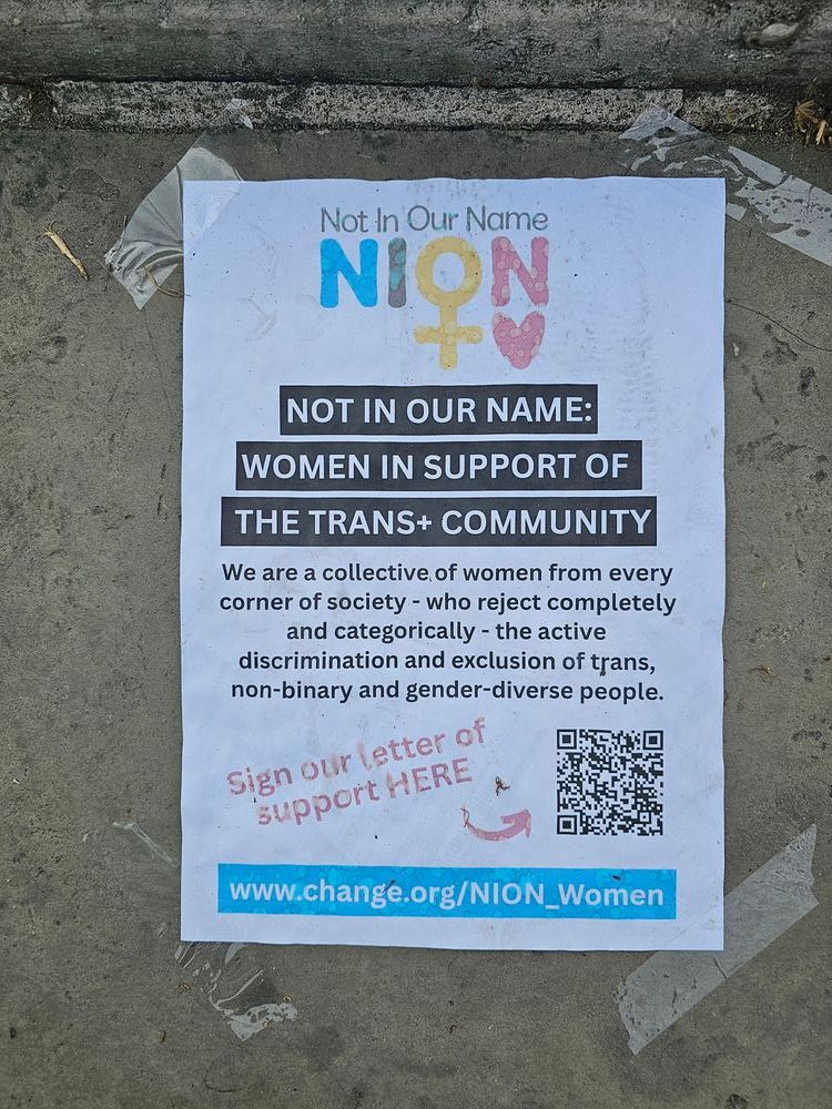 A photo of a poster, which reads "Not in our name: Women in support of the Trans+ community. We are a collective of women from every corner of society - who reject completely and categorically - the active discrimination and exclusion of trans, non-binary and gender-diverse people." 