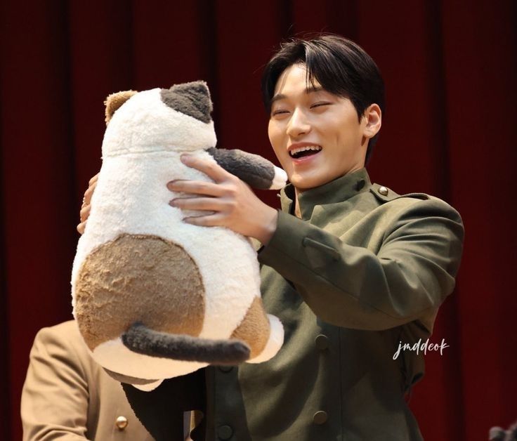 sannie being very smiley holding a big calico cat plush