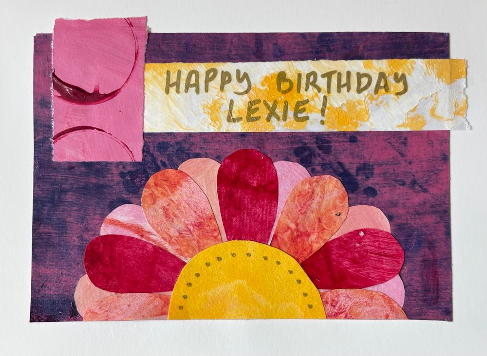 The card is made of papers painted and decorated using various techniques, then collaged to create a colourful orange, pink and red flower on a purple background. A banner across the top reads “Happy Birthday, Lexie!”