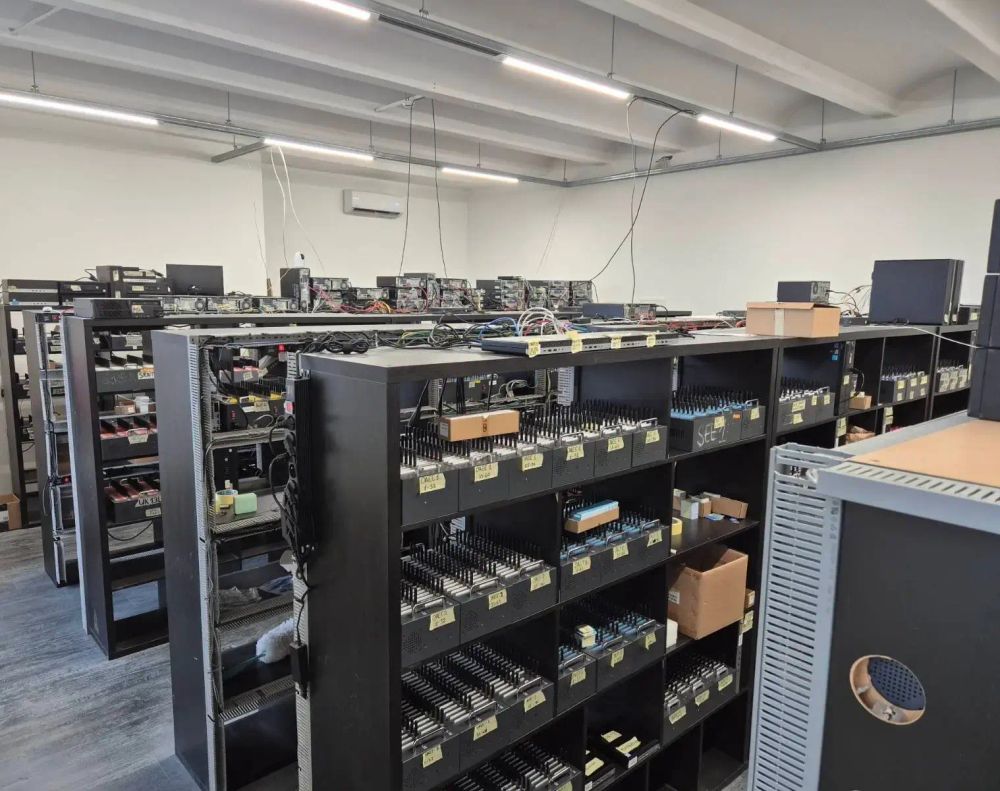 Salle remplie d’étagères contenant des centaines de boîtiers électroniques et de cartes SIM connectés à des serveurs et à du matériel réseau