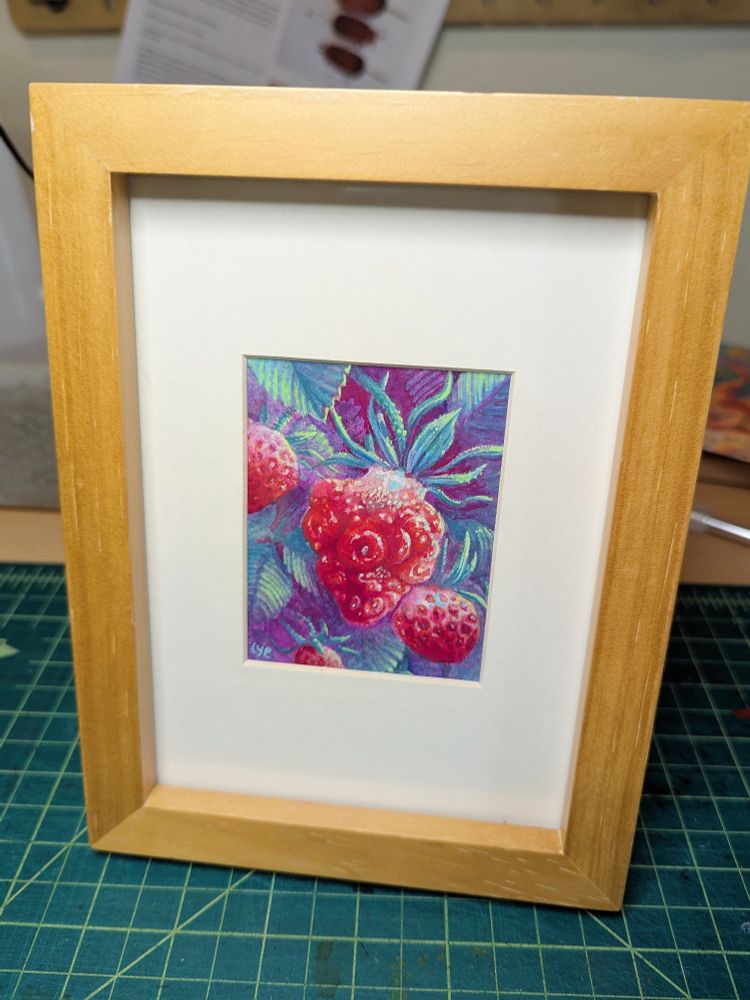 A matted and framed painting of a mutated strawberry. The lumpy body of the strawberry has an uneven distribution of seeds and several glossy, bumpy spots. It sits in contrast to a background of foliage with shadows in the purple range.