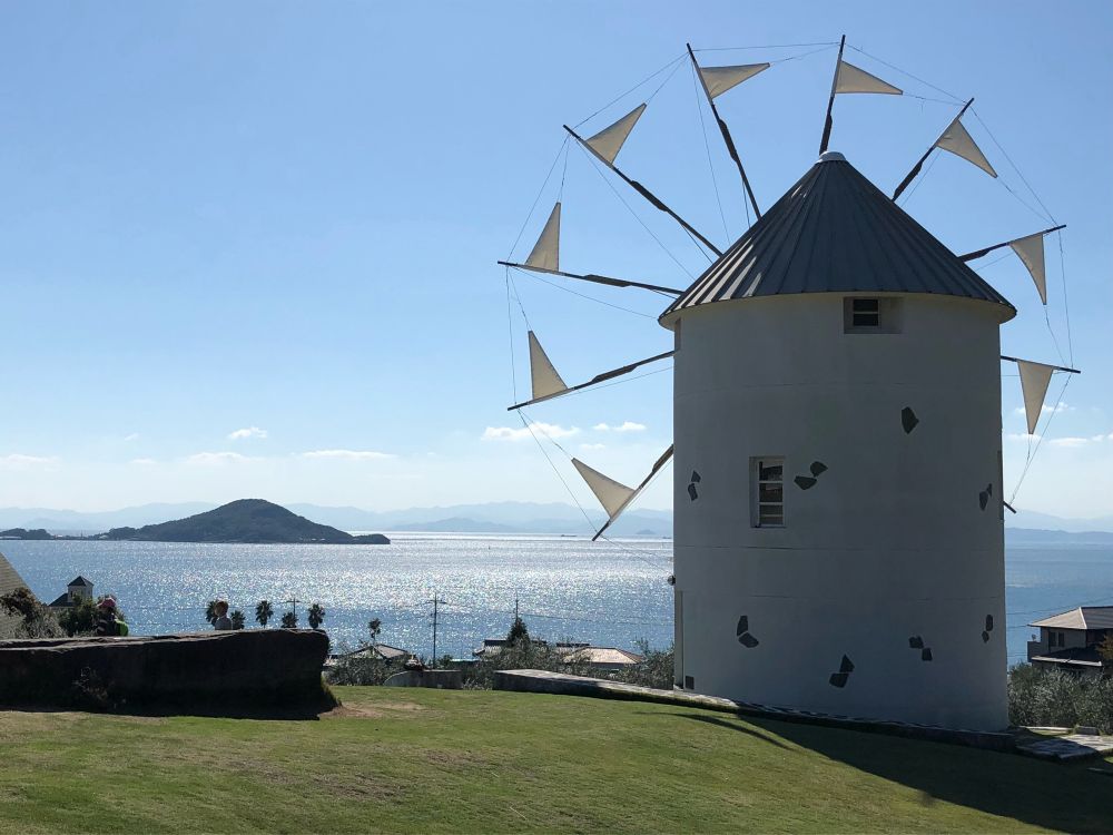 Moulin à vent au bord de la mer de Seto avec une île à l’horizon