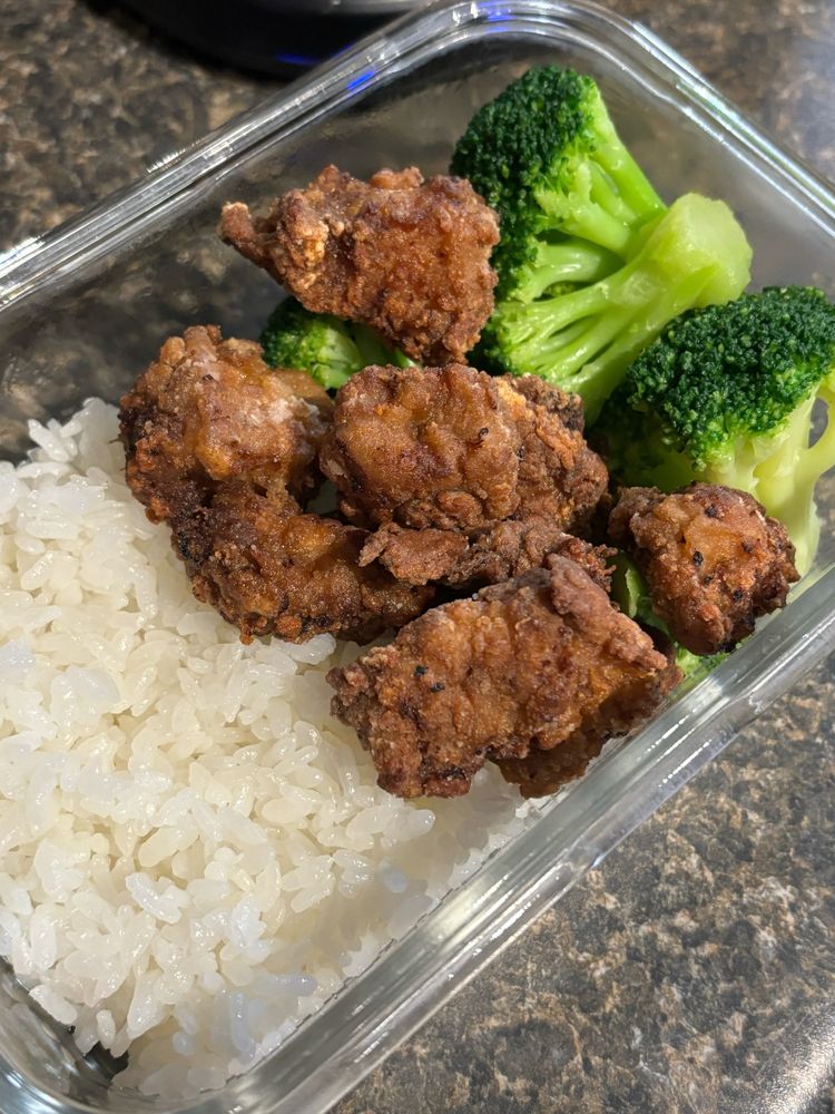 A Tupperware container with rice, Japanese chicken karaage, and broccoli.