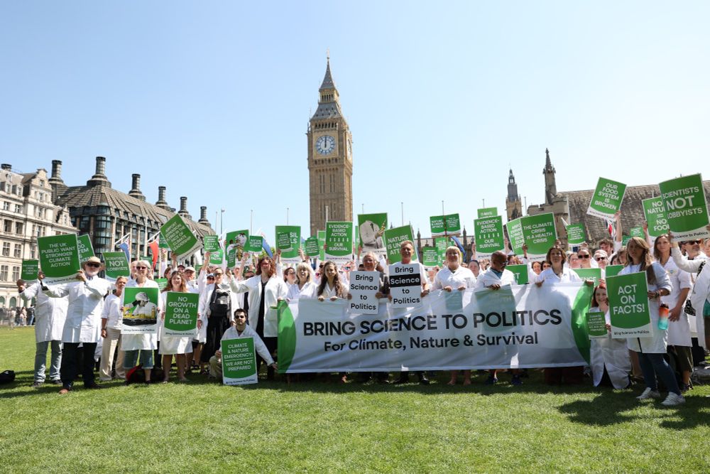 A large group of scientists in white lab coats protest in Parliament Square over Government's failure to address the polycrisis.  Image credit: Kirk Pritchard. 