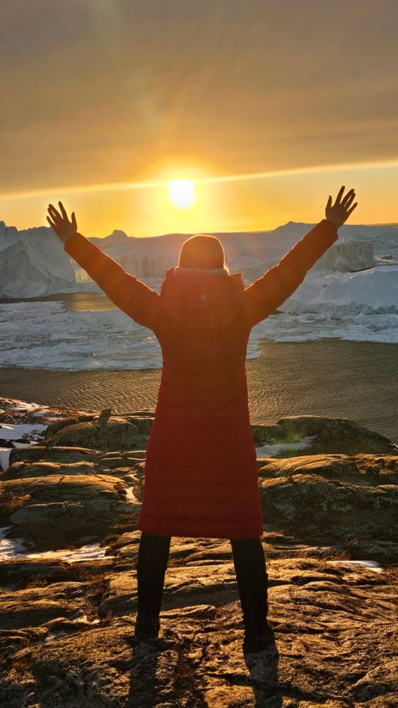 Icefjord! I'm standing in front of icebergs while the sun is slowly setting.