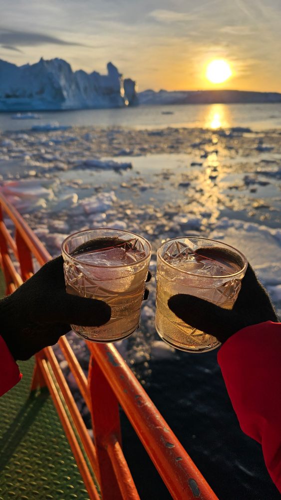 Enjoying labrador tea together on the boat while the sun is setting