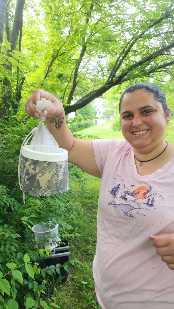 CVM Public Health student smiles at her mosquito collection. She collected mosquito w a cdc light trap bites with dry ice (which sublimates and emits CO2).