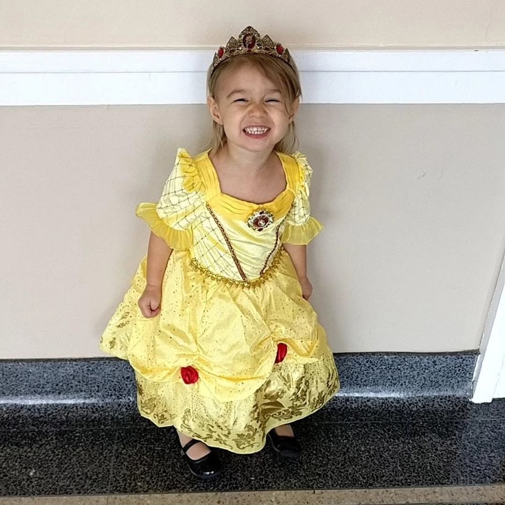 Young child dressed in yellow ball gown costume from Beauty and the Beast. 