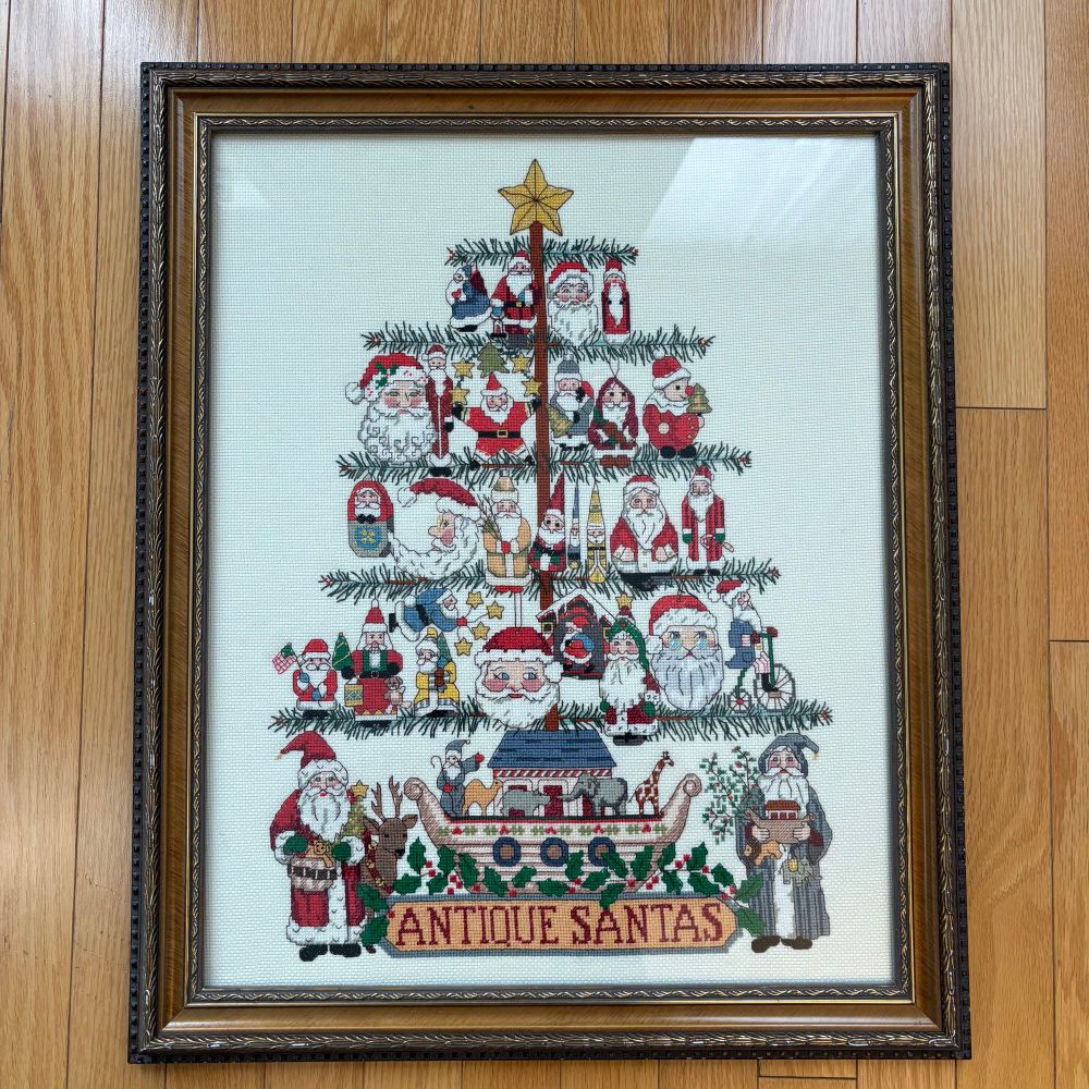Framed cross stitch of a modified version of Antique Santa Tree from Dimensions.
