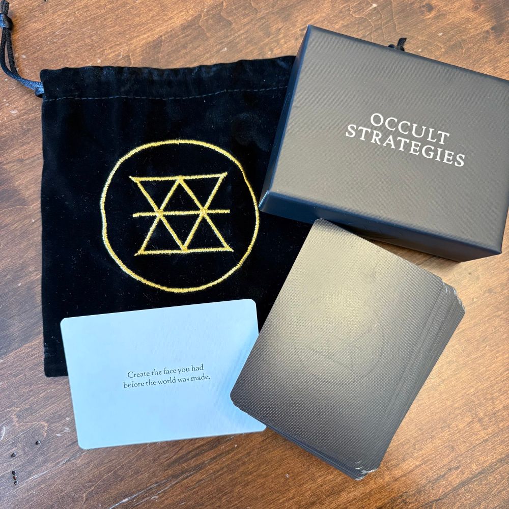 An image of the Occult Strategies card deck with box and embroidered drawstring bag. 