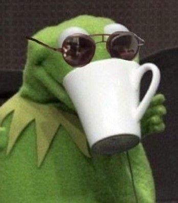 Green puppet frog wearing sunglasses drinking out of a white mug