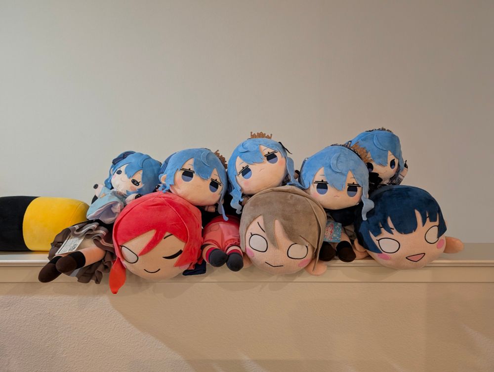 a collection of suisei plushies poised atop love live nesos