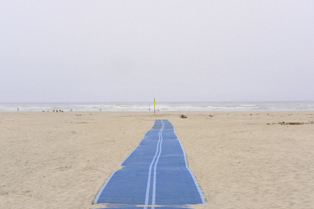 Beach coastline with a walking mat in the center