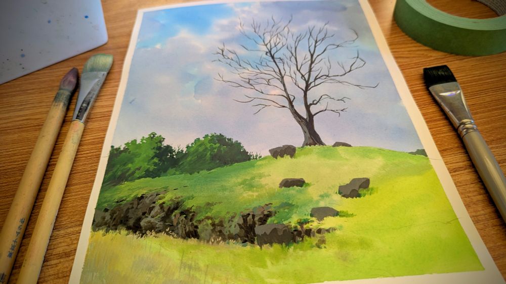 gouache painting of a leafless tree standing along on a grassy hill

it looks like there are some large boulders around it but those will magically become cows later on