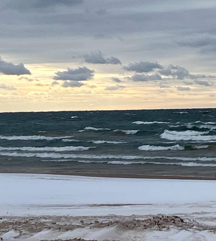 Lake Michigan with snowy beach and lemony clouds in the sky 