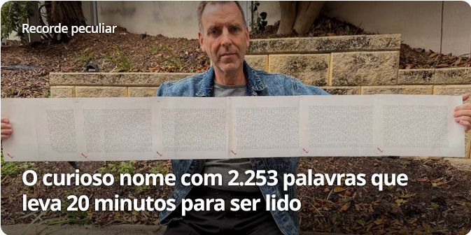 Screenshot de manchete de reportagem no G1 com os dizeres: "O curioso nome com 2.253 palavras que leva 20 minutos para ser lido.". Ilustrando a manchete, temos a foto de um homem segurando uma longa folha de papel que parece conter um texto enorme.